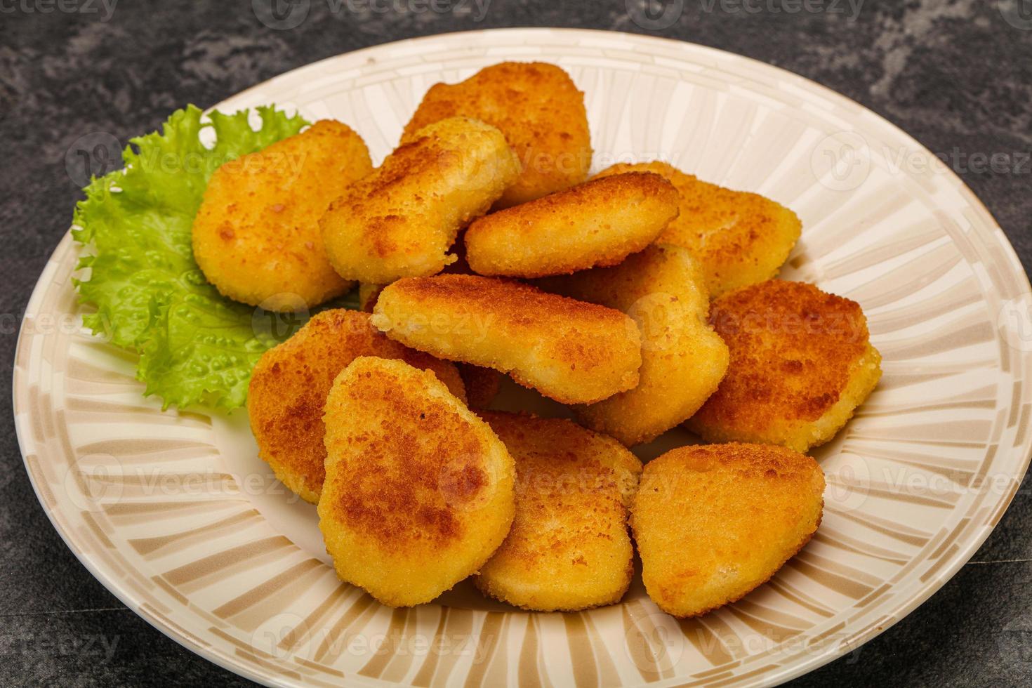 frittierte Chicken Nuggets, serviert mit Salatblättern foto