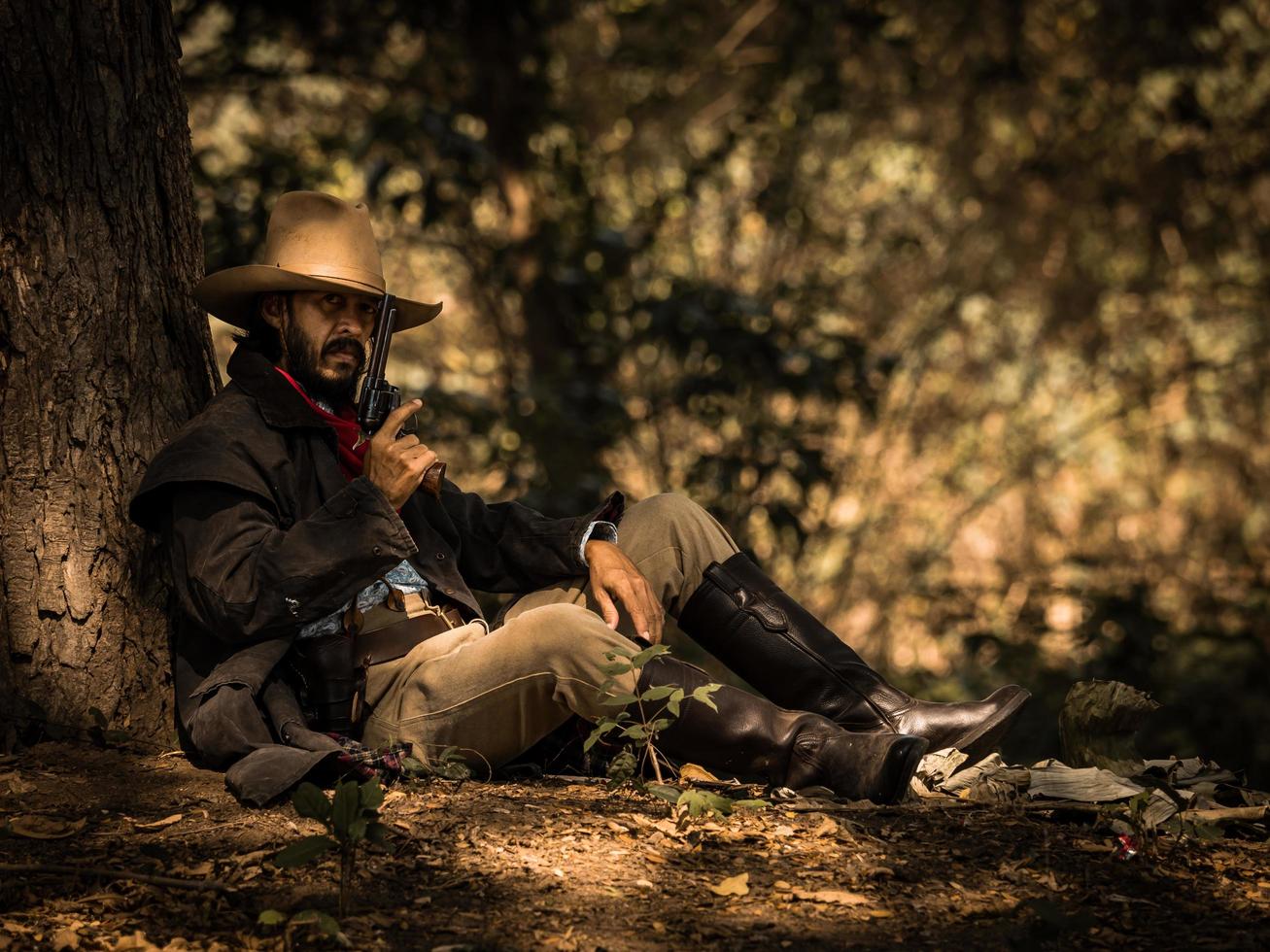 Ein älterer Cowboy saß mit einer Waffe da, um die Sicherheit des Lagers im westlichen Bereich zu bewachen foto