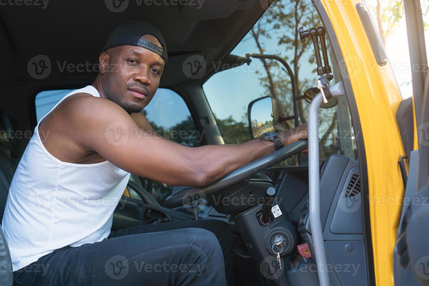 lkw-fahrer mann lächelt zuversichtlich im versicherungsfrachtverkehr foto