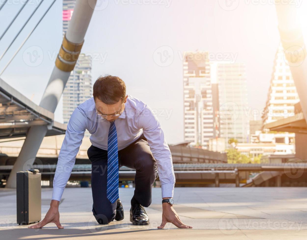 Geschäftsmann in Startposition Läufer Stadt Hintergrund, Start für Erfolgskonzepte foto