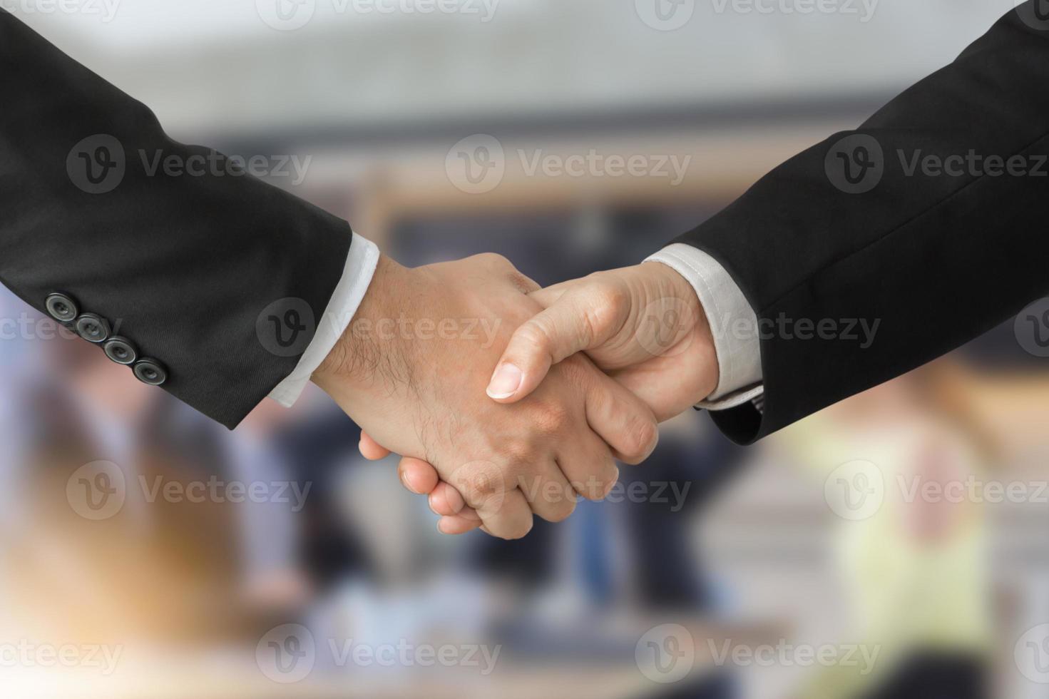 Teamkonzept für Erfolg und Glück, Geschäftsmann-Handshake über verschwommenem Hintergrund von Geschäftsleuten foto