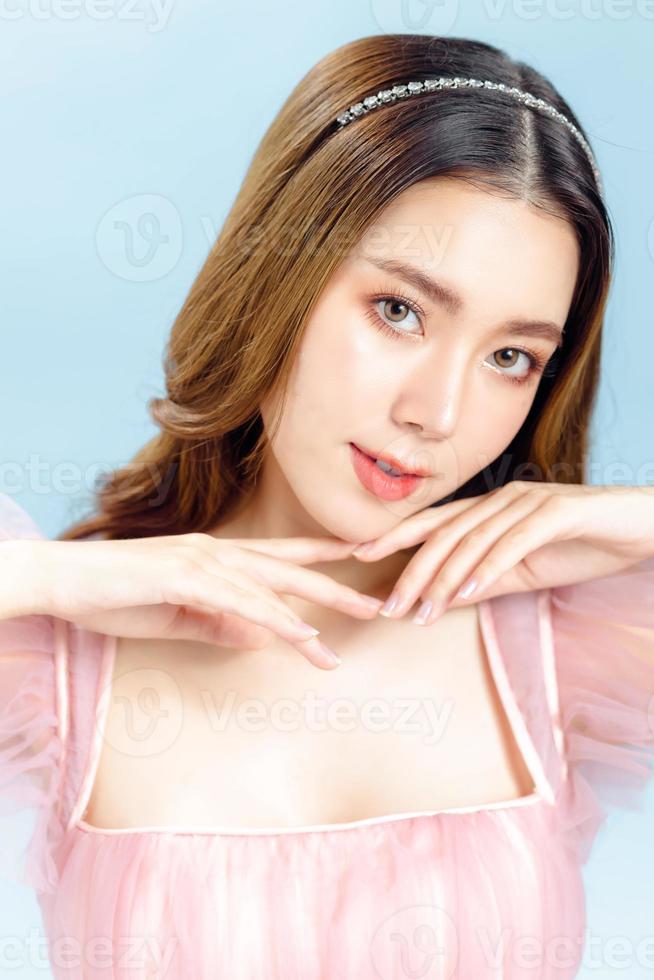 asiatische frau mit schönem gesicht und frischer, glatter haut ist in rosa gekleidet. foto