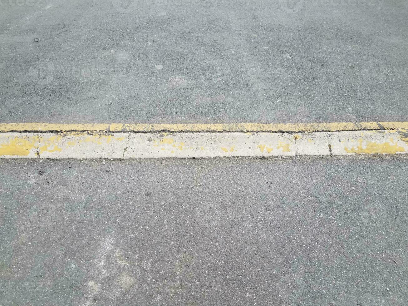 erhöhter asphalt- oder pflasterweg mit gelbem bordstein oder rampe foto