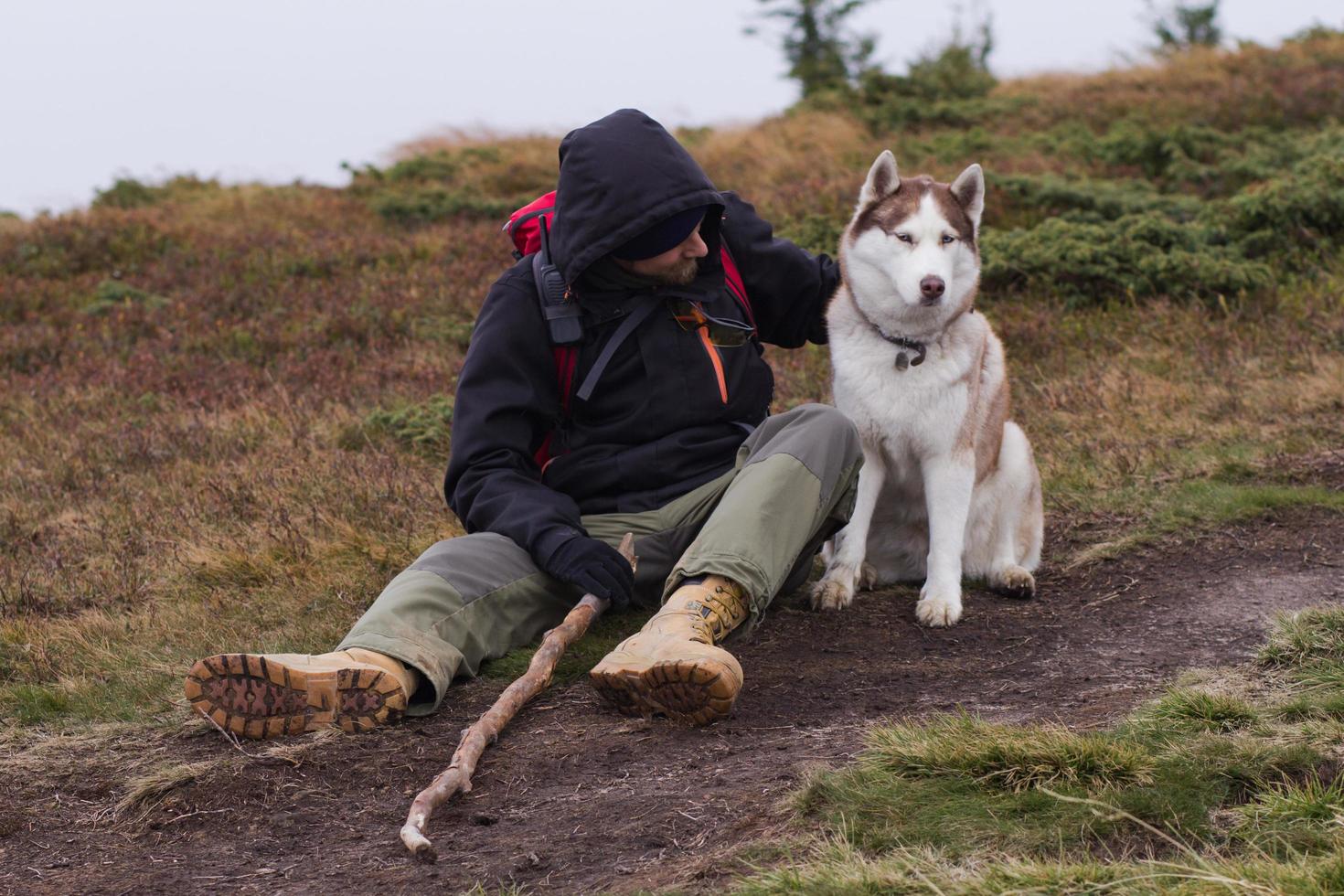 junger mann mit heiserem hund in den bergen, reise mit hunden foto