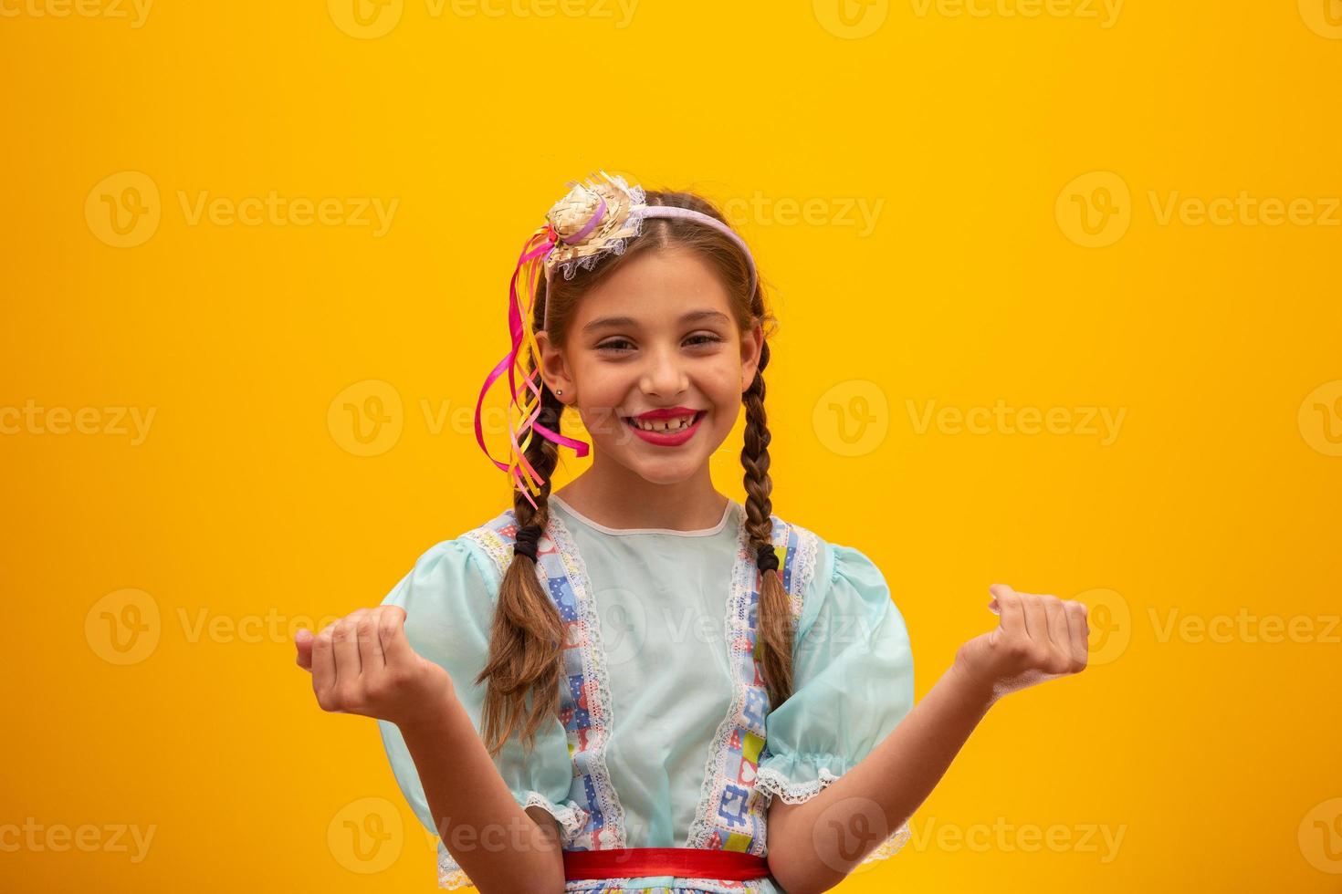 kind in typischer kleidung der berühmten brasilianischen party namens festa junina zur feier von sao joao. schönes Mädchen auf gelbem Hintergrund. foto