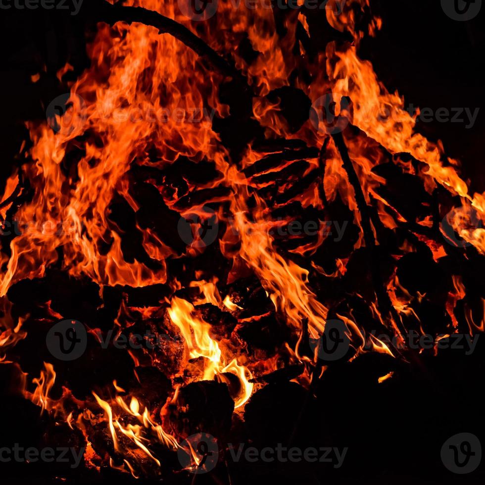 feuerflammen auf schwarzem hintergrund, lodernder feuerflammentexturhintergrund, schön, das feuer brennt, feuerflammen mit holz und kuhdunglagerfeuer foto