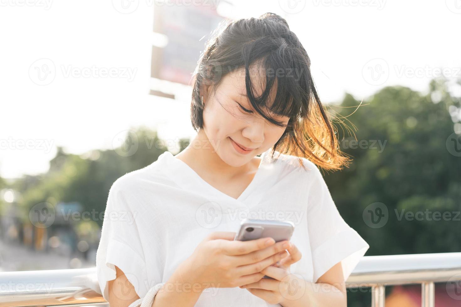 junge erwachsene asiatische geschäftsfrau, die handy verwendet, findet dating-beziehung über anwendung. foto