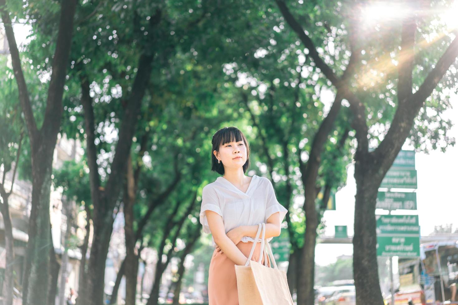 asiatische Geschäftsfrau des jungen Erwachsenen, die im öffentlichen Park im Freien geht foto