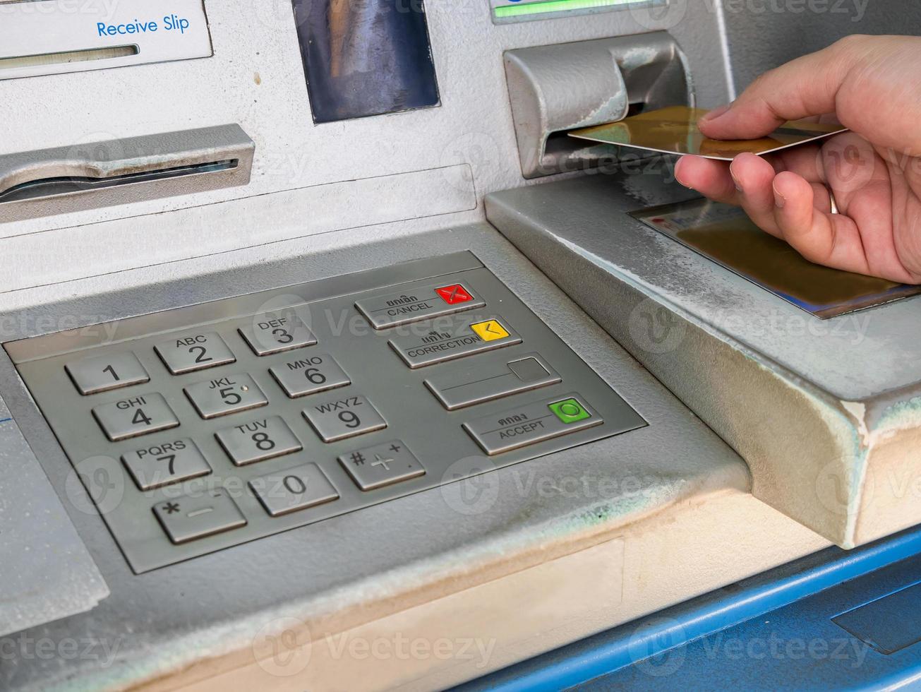 weibliche hand, die atm-karte in atm-bankmaschine einführt foto