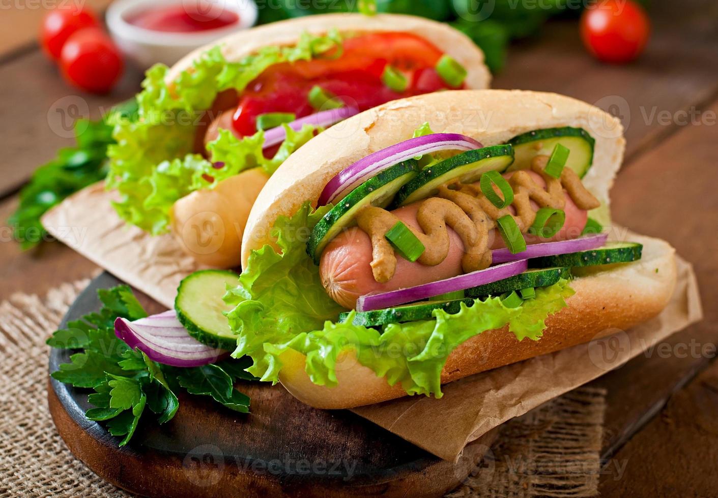 Hotdog mit Ketchup, Senf, Salat und Gemüse foto