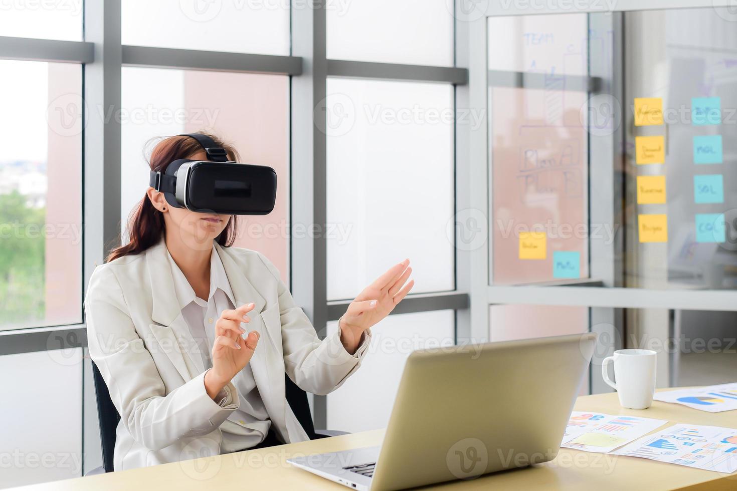 kaukasische geschäftsfrau sind videokonferenz mit visueller realität oder vr-headset-brillentechnologie im modernen büro. metaverse und virtuelles technologiekonzept. foto