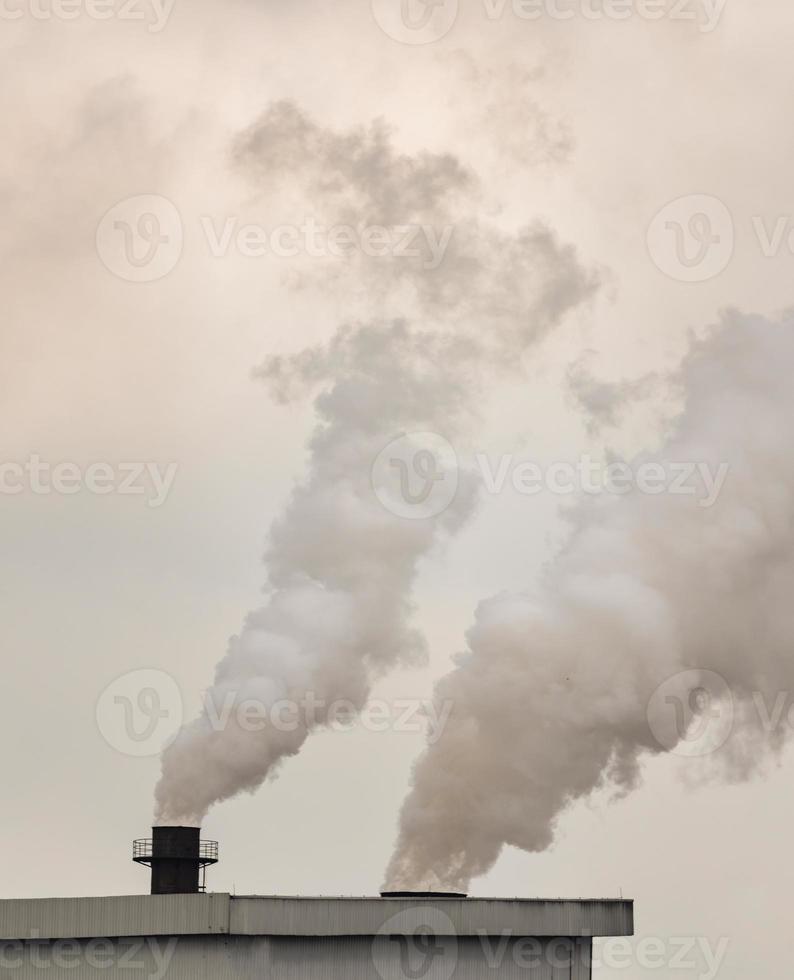 Emission von Rauch in die Luft aus Schornsteinen von Industrieanlagen foto