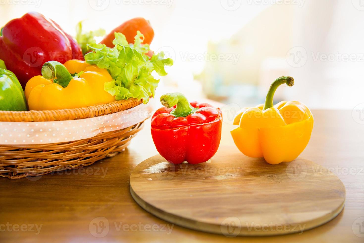 Paprika auf Hackklotz mit gesundem Gemüse im Korb foto
