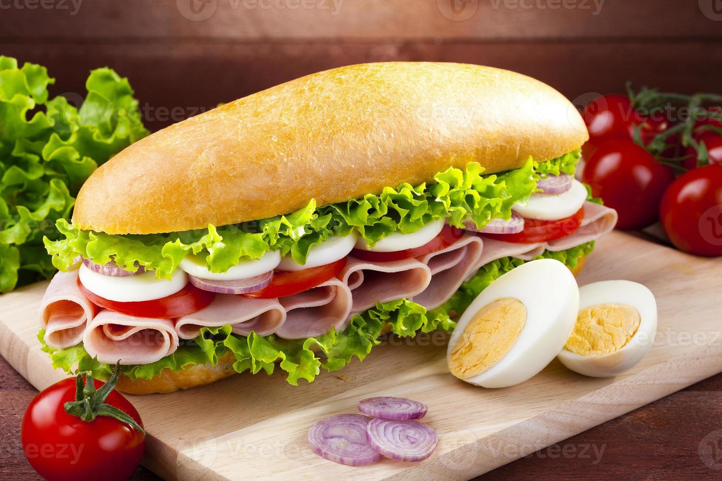 großes Sandwich mit Schinken, Käse und Gemüse foto
