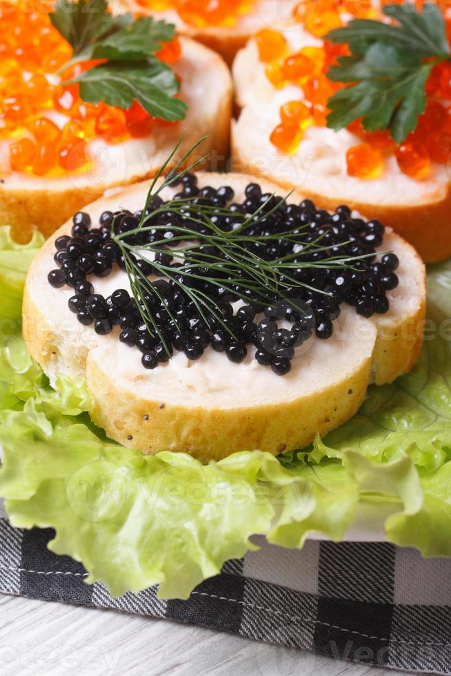 Sandwiches mit rotem und schwarzem Fischkaviar auf Salat foto