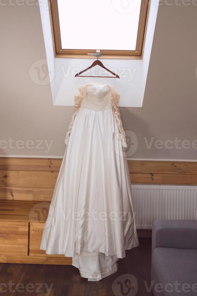 Weißes Hochzeitskleid auf dem Kleiderbügel foto