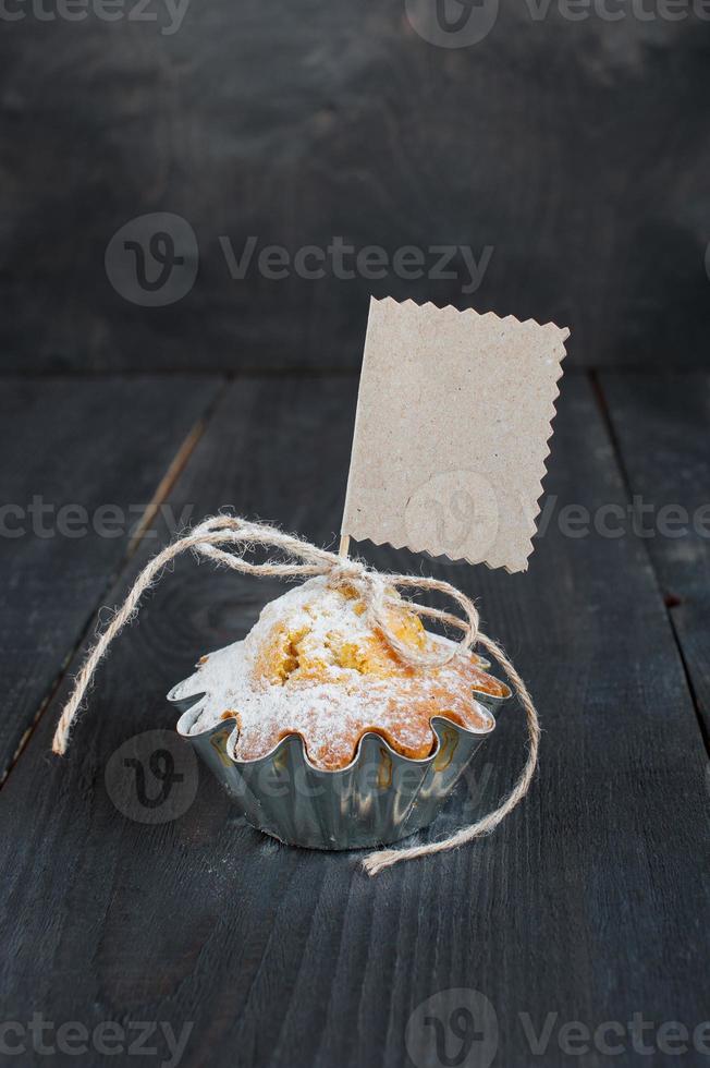 Cupcake mit leerem Etikett auf dem Holztisch foto