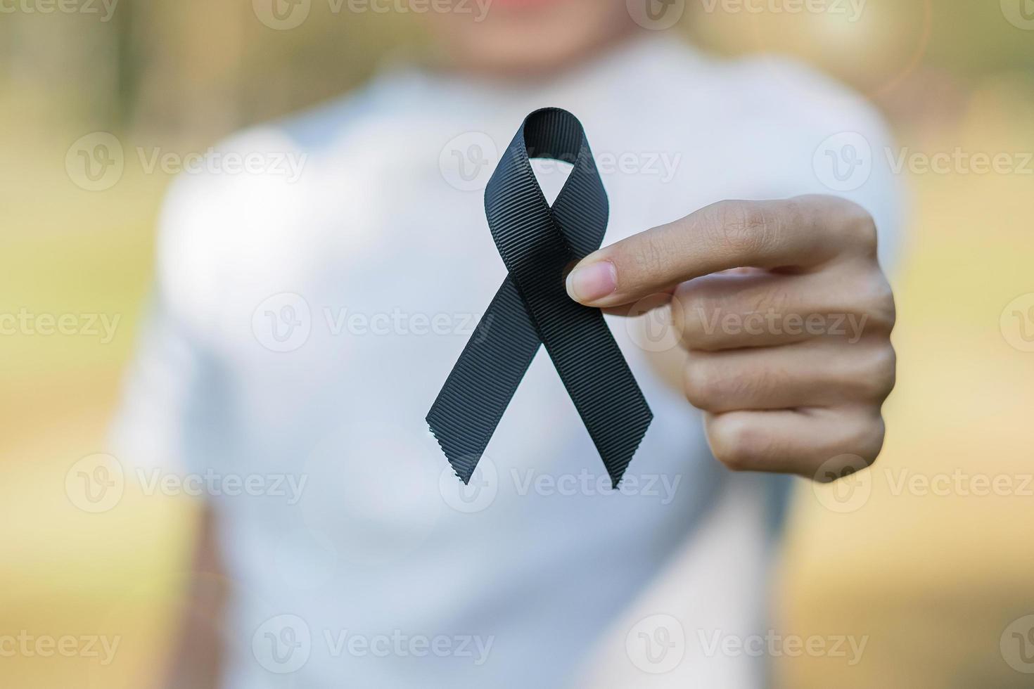 melanom und hautkrebs, bewusstseinsmonat für impfverletzungen und ruhe in friedenskonzepten. Frau mit schwarzem Band foto