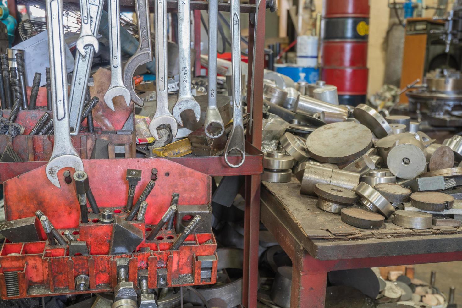 Viele Schraubenschlüssel hängen an Metallbügeln, unordentliche Werkzeuge im Hintergrund foto