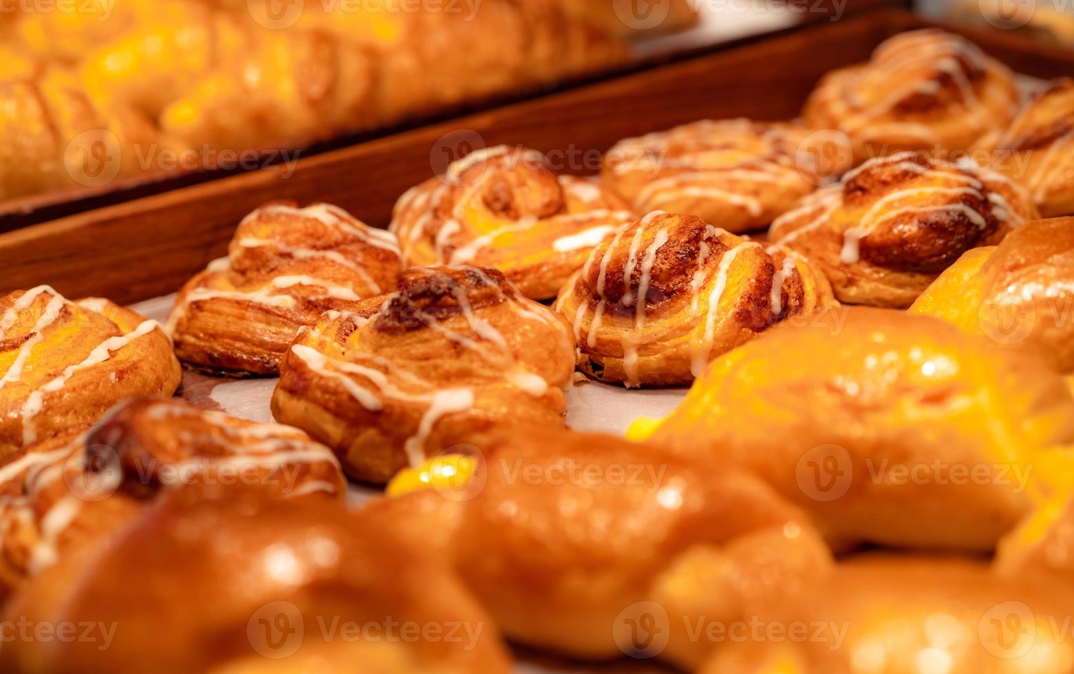 Bäckerei in braunem Holztablett in der Bäckerei. frisch gebackenes Backwarenprodukt. süße Brotanzeige auf der Theke. Kohlenhydrate essen. Snack zum Frühstück oder Mittagessen. Bäckerei Einzelhandel. hausgemachtes Bäckereigeschäft. foto