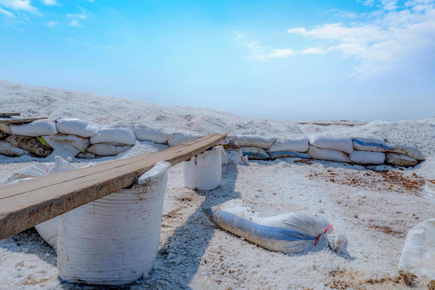 Sole-Salzfarm mit blauem Himmel und weißen Wolken. Haufen von Bio-Meersalz in der Nähe des Lagers. Rohstoff der Salzindustrie. Ozeansalz. sommerreise in thailand-konzept. Natriumchlorid-Mineral. foto