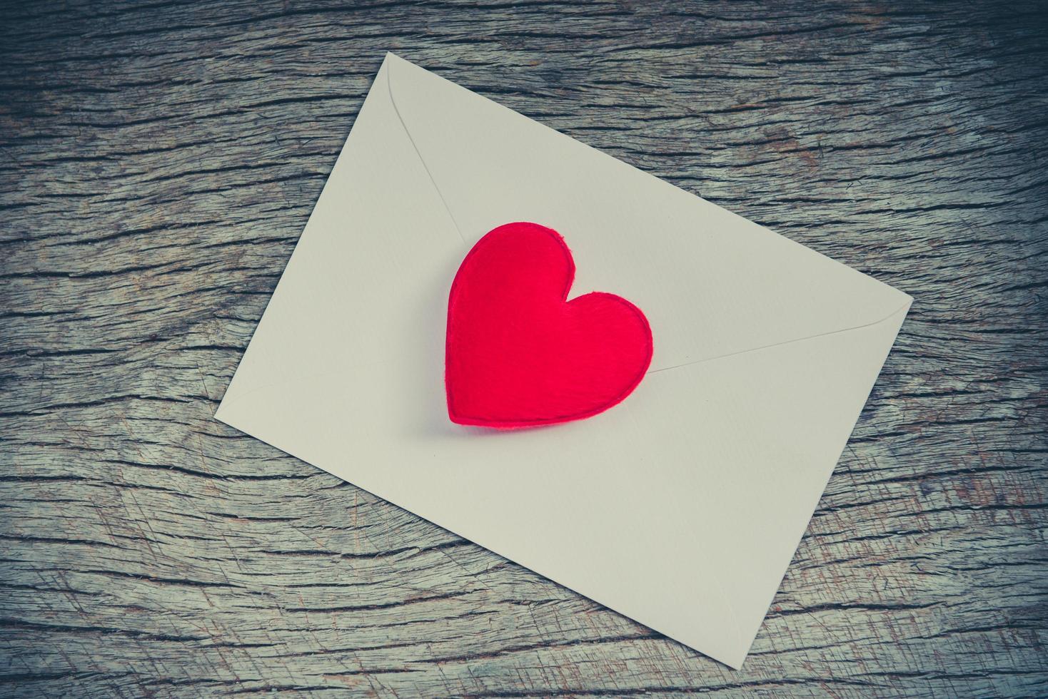 Einladungskarte Hochzeit auf Holz Hintergrund - romantische Liebe Valentinstag Karte Umschlag Briefpost mit rotem Herzen foto