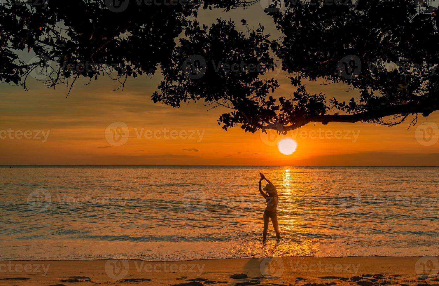 Silhouette Rückansicht einer sexy Frau, die einen wunderschönen Sonnenuntergang am tropischen Paradiesstrand beobachtet. glückliches mädchen trägt bikini und strohhut entspannende sommerferien. Urlaubsreise. sommergefühl. friedliches Leben. foto