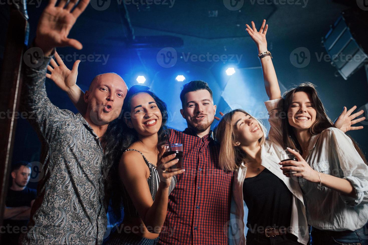 tanzen, trinken und Spaß haben. Schöne Jugendliche feiern zusammen mit Alkohol im Nachtclub foto