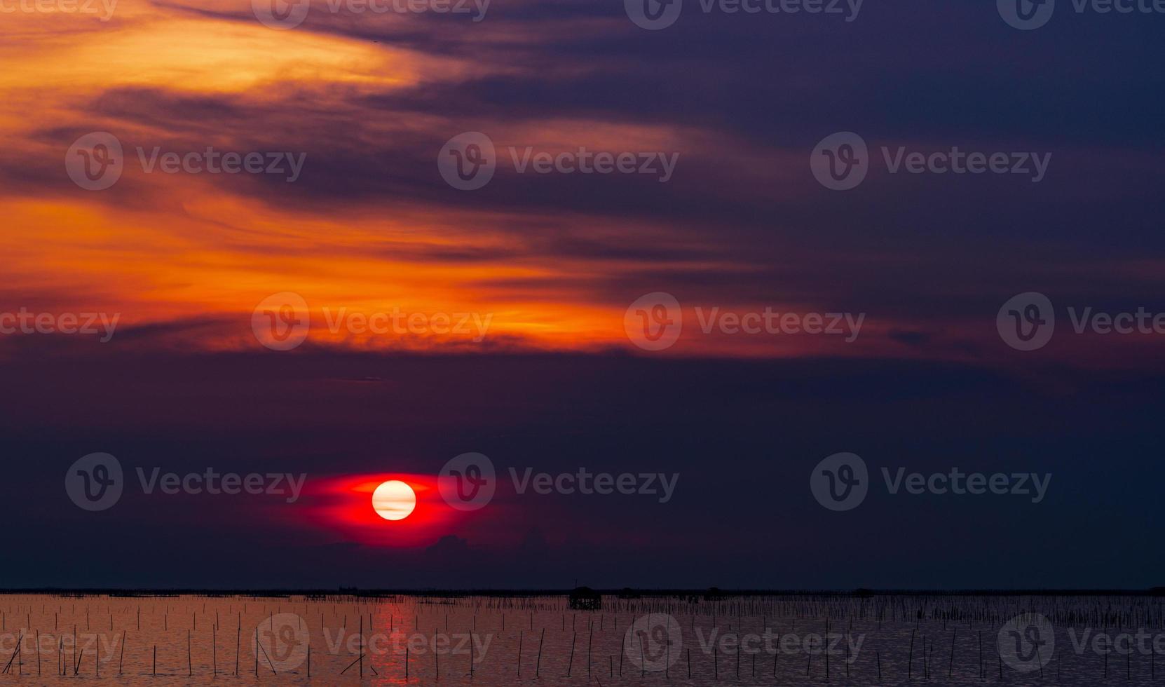 schöner sonnenuntergang über dem meer. dunkelroter und orangefarbener Sonnenuntergangshimmel und Wolken. Naturhintergrund für ein ruhiges und friedliches Konzept. Sonnenuntergang in Chonburi, Thailand. emotionale große sonne in der dämmerung. Dämmerung Himmel. foto