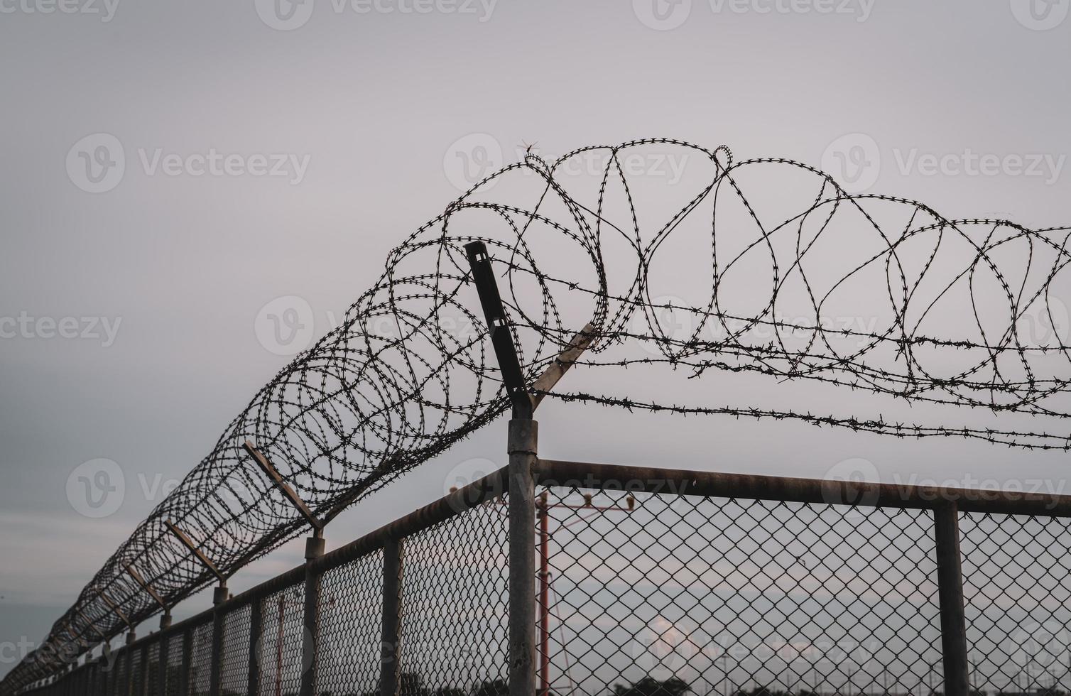 Sicherheitszaun des Gefängnisses. Stacheldraht Sicherheitszaun. Stacheldraht Gefängniszaun. Barrieregrenze. Grenzsicherungsmauer. Gefängnis zur Festnahme von Kriminellen oder Terroristen. Privater Bereich. Militärzonenkonzept. foto