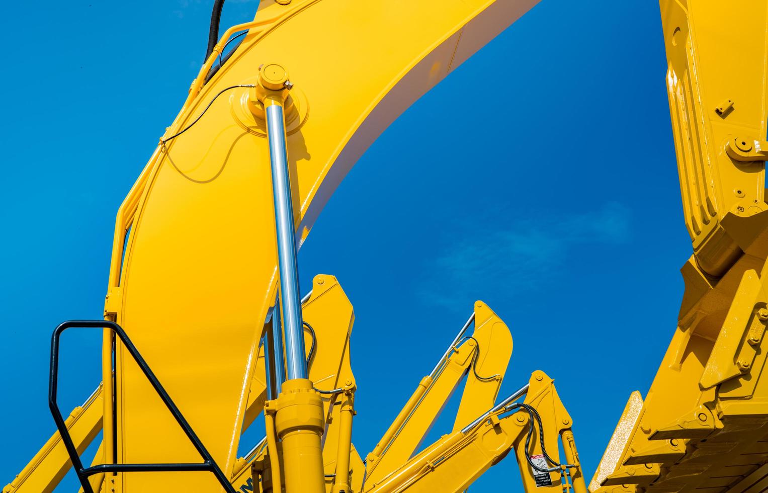 Gelber Bagger mit hydraulischem Kolbenarm gegen strahlend blauen Himmel. schwere Maschine für den Aushub auf der Baustelle. hydraulische Maschinen. riesiger Bulldozer. Schwerindustrie foto