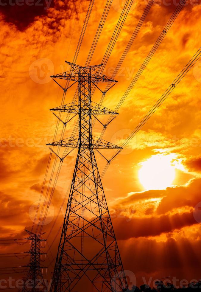 Hochspannungsmast und Übertragungsleitungen. Strommasten bei Sonnenuntergang. Kraft und Energie. Energieeinsparung. Hochspannungsnetzturm mit Drahtkabel an der Verteilerstation. goldener Himmel. foto