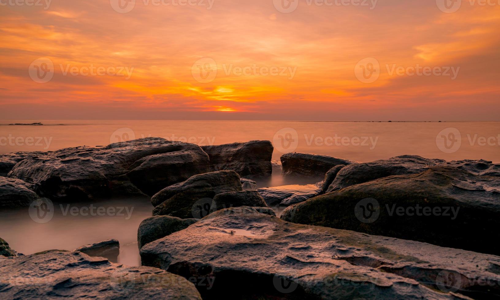 Felsen am Steinstrand bei Sonnenuntergang. schöner strand sonnenuntergang himmel. Dämmerung Meer und Himmel. tropisches meer in der dämmerung. Dramatischer Himmel und Wolken. abstrakter hintergrund des sonnenuntergangs. beruhige und entspanne das Leben. Naturlandschaft. foto