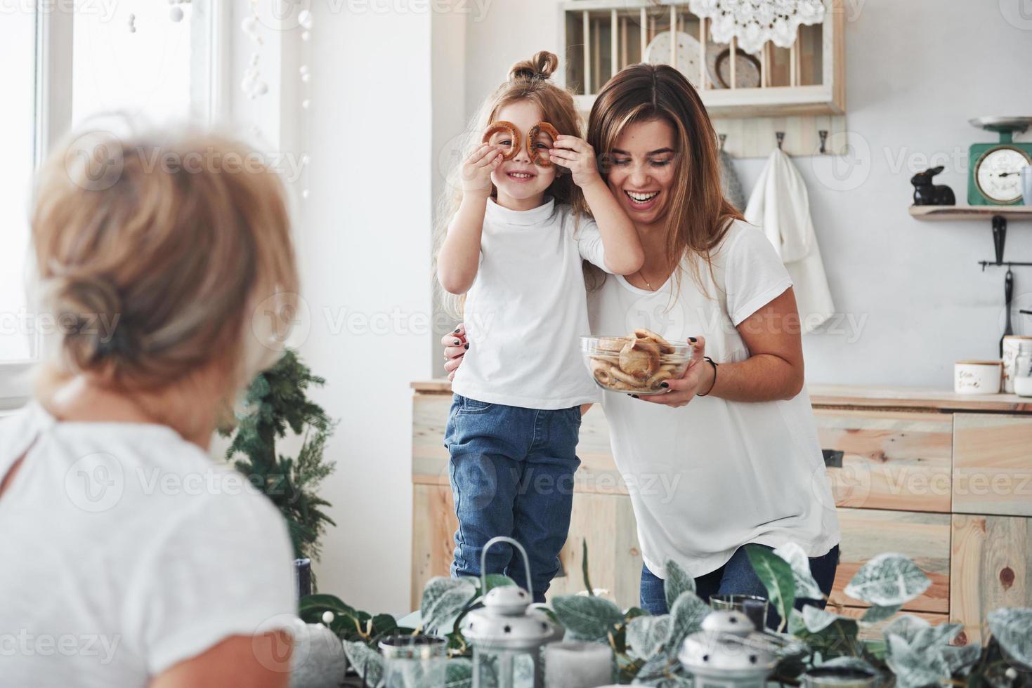 Schau mich an. Mutter, Großmutter und Tochter amüsieren sich in der Küche foto