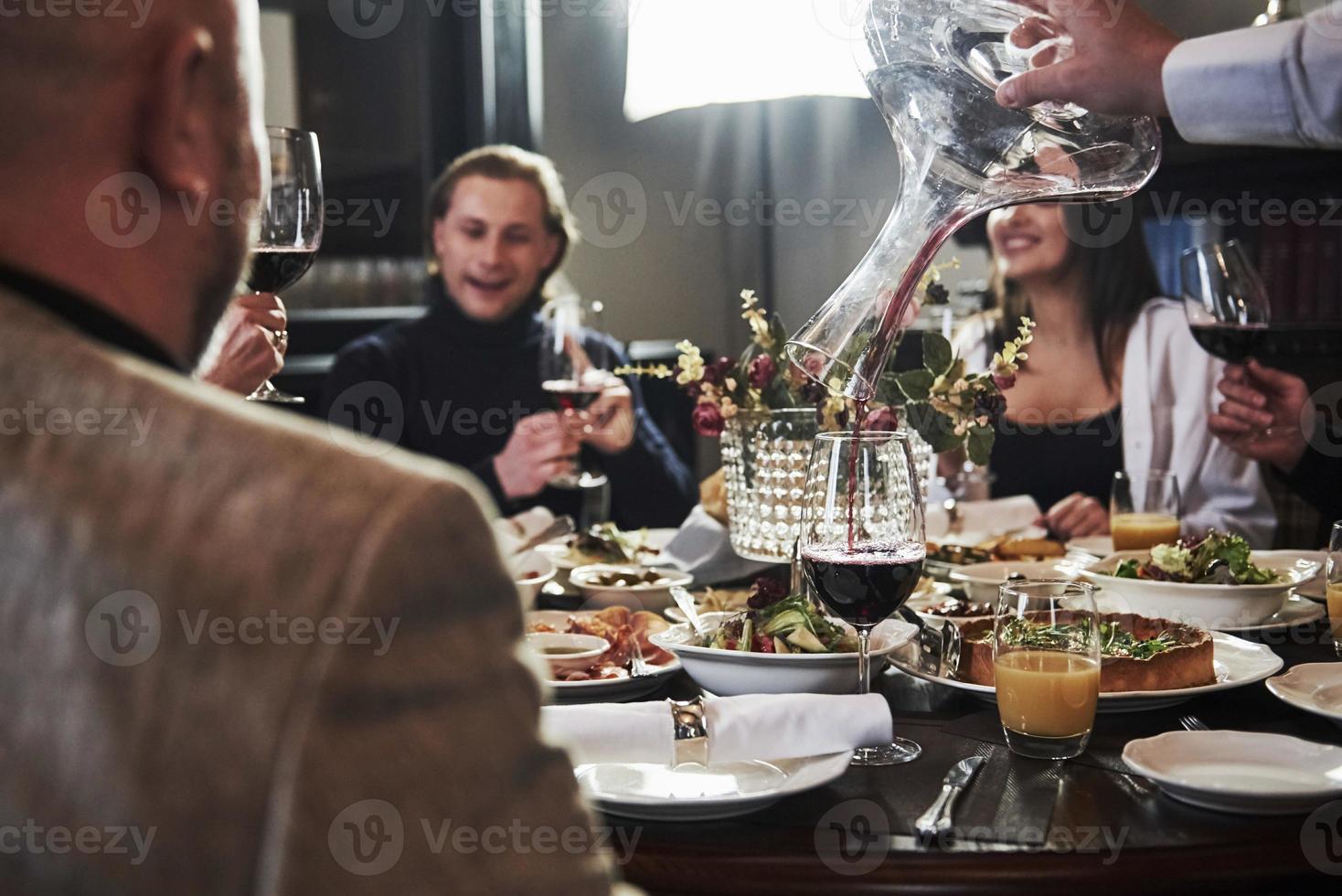 über einige Ereignisse sprechen. Freunde der Familie haben eine schöne Zeit in einem schönen modernen Luxusrestaurant foto