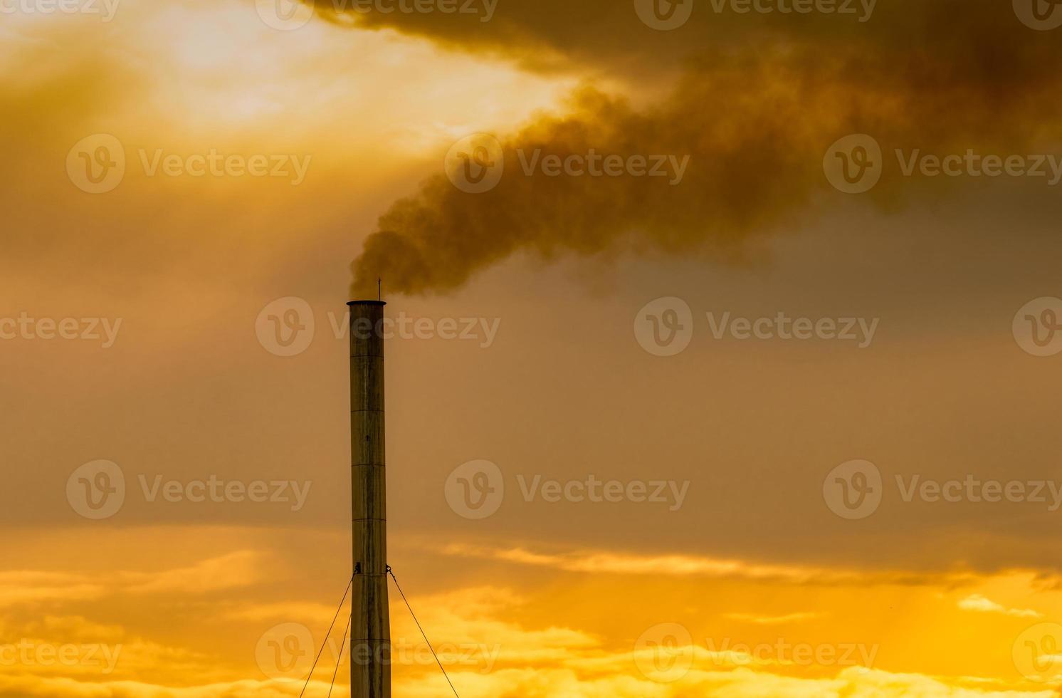 Luftverschmutzung durch Fabrik. Rauch aus dem Schornstein des Industrierohrs am Himmel bei Sonnenuntergang. konzept des globalen erwärmungsproblems. schlechte Luftqualität. Emissionsfaktoren für Luftschadstoffe. Luftverschmutzung. Uhr 2,5 Staub. foto