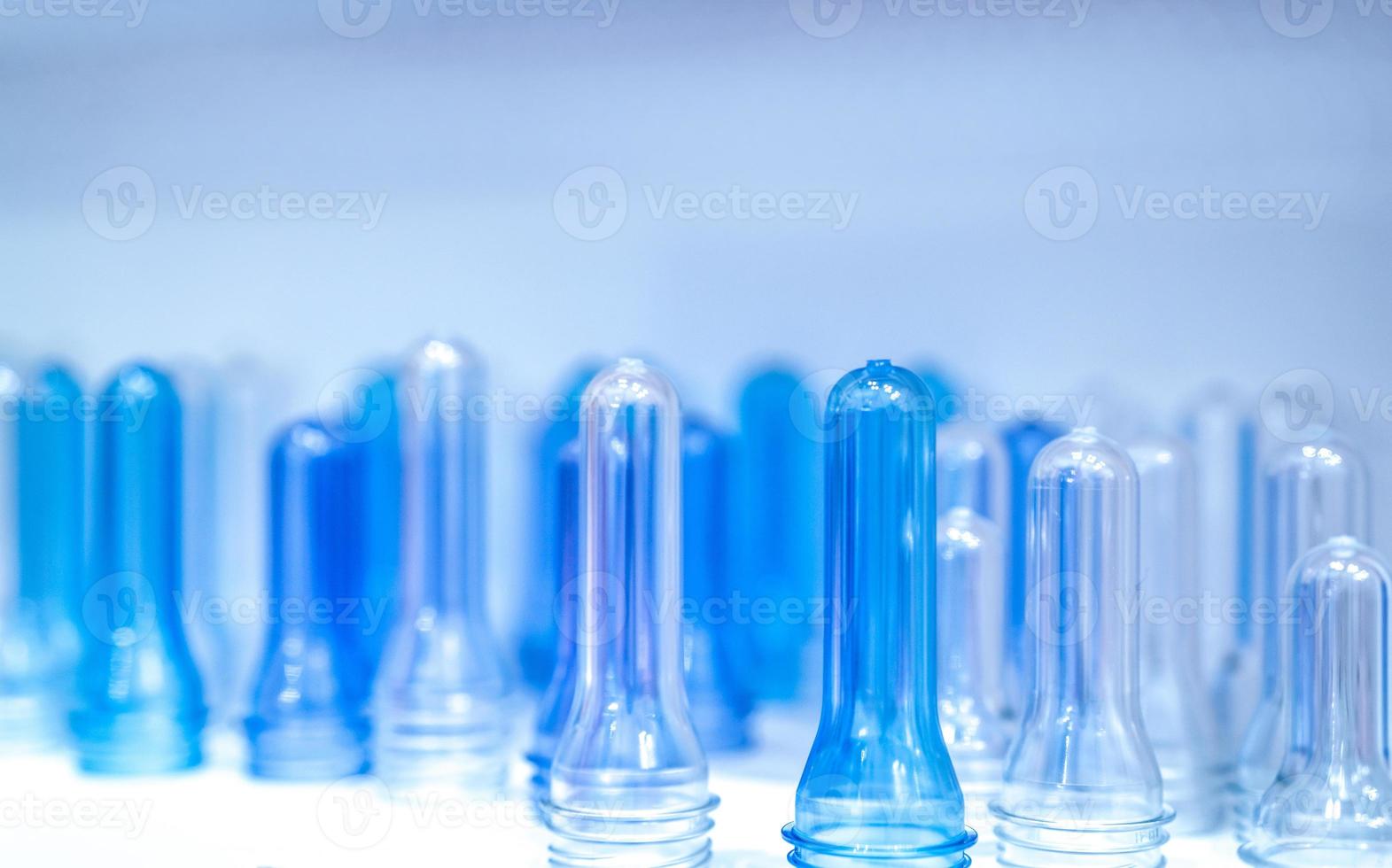 PET-Flaschen-Preforms vor dem Blasformen, Abfüllen und Etikettieren. Vorformlinge für blaue PET-Flaschen für die Getränkeindustrie. Rohstoff für PET-Flasche mit Schraubverpackung. Kunststoffkonzept recyceln. foto