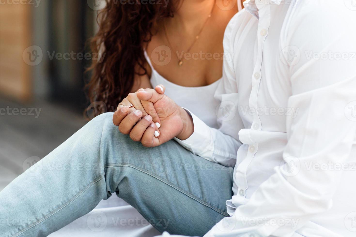 Zugeschnittenes Foto von Händen Frau und Mann verbringen Zeit miteinander und sitzen im Freien, umarmen und lachen auf der Sommerterrasse, verliebtes Paar am Valentinstag