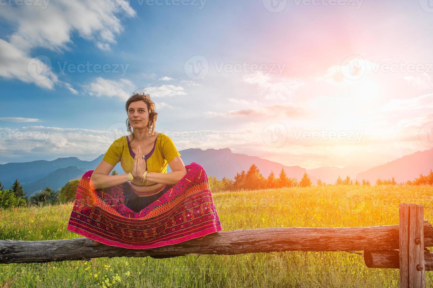 spirituelle Praktiken eines Mädchens, das auf dem Zaun sitzt foto