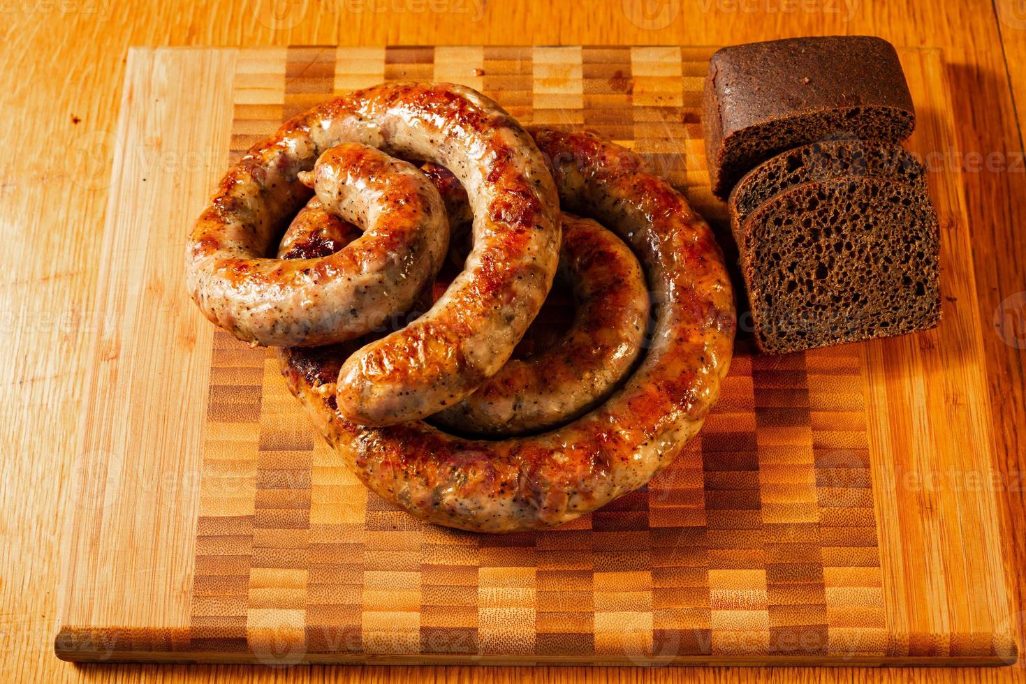 Grillwürste auf einem Schneidebrett mit Brot foto