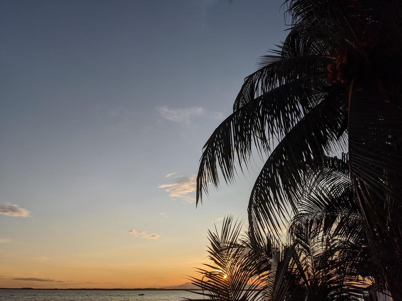 der Blick auf das Naturphänomen des Sonnenuntergangs an einem wunderschönen Strand foto