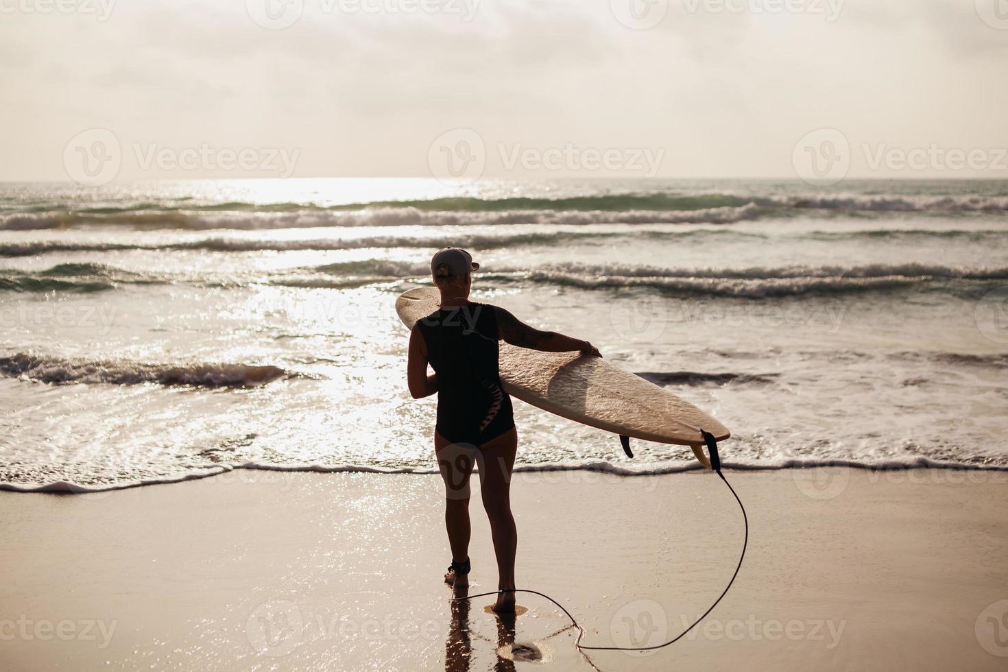 Surffrau mit Surfbrettrückansicht foto