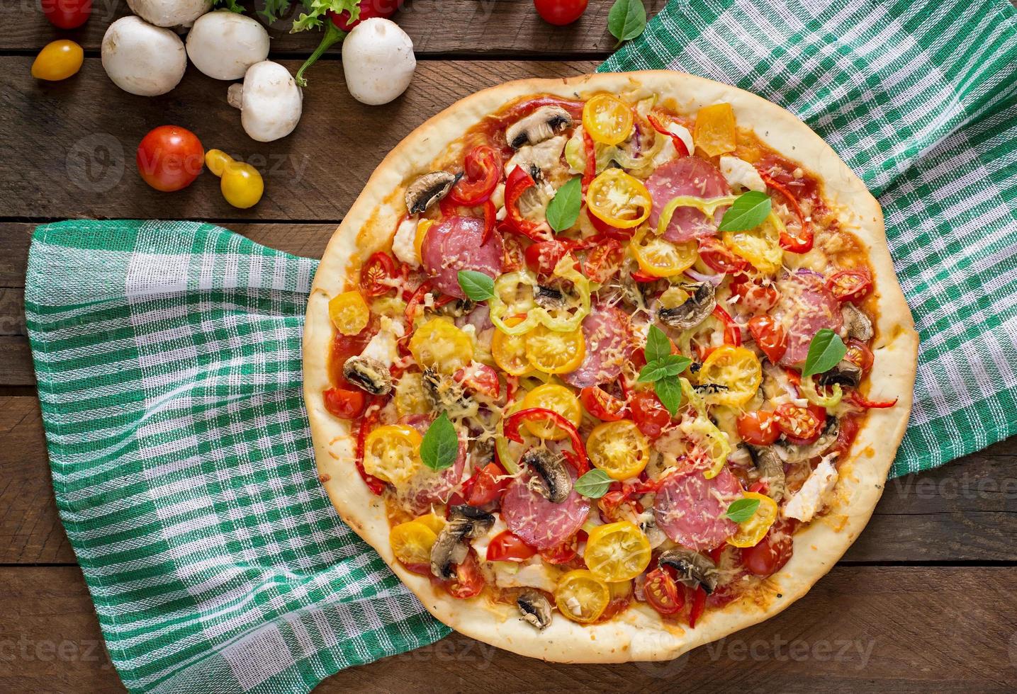 Pizza mit Salami, Tomate, Käse und Pilzen foto