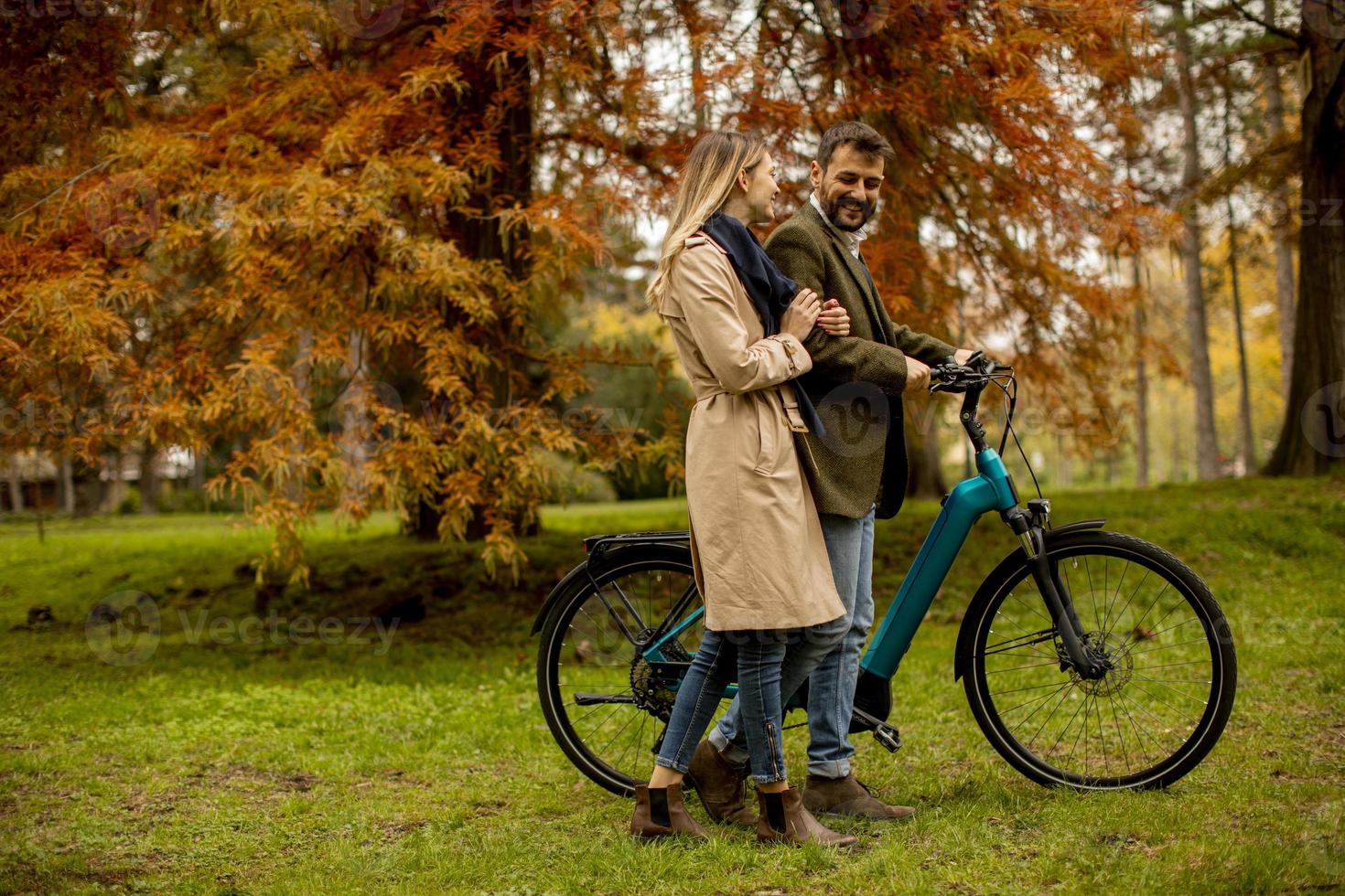 junges Paar im Herbstpark mit Elektrofahrrad foto