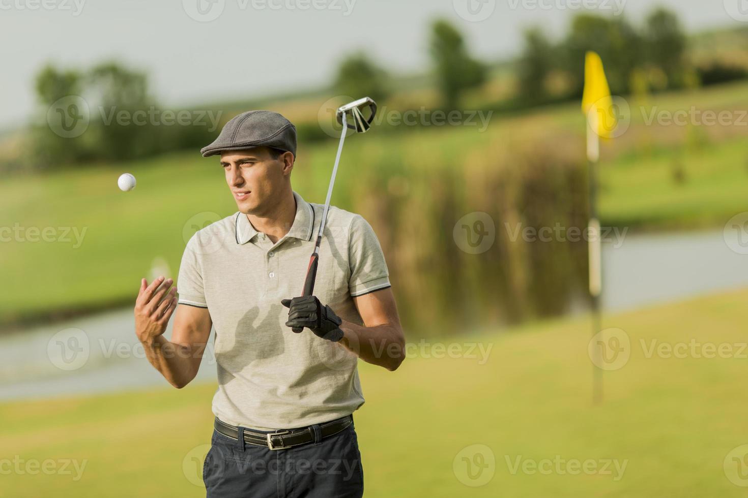 junger Mann, der Golf spielt foto