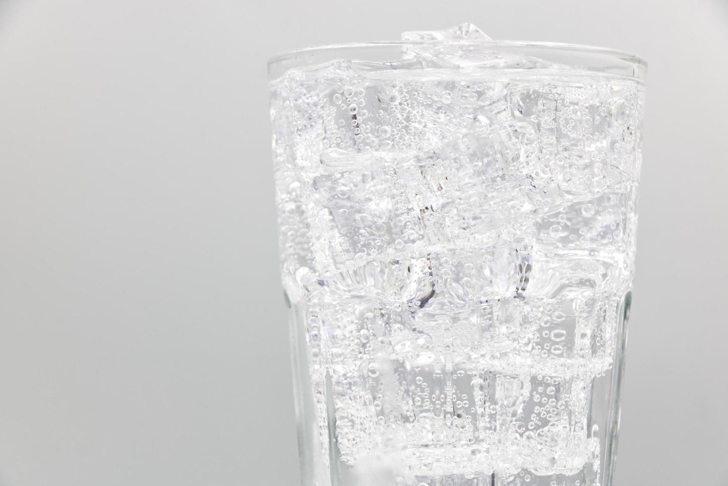 Soda Sprudelwasser mit Eis im Glas auf weißem Hintergrund. foto