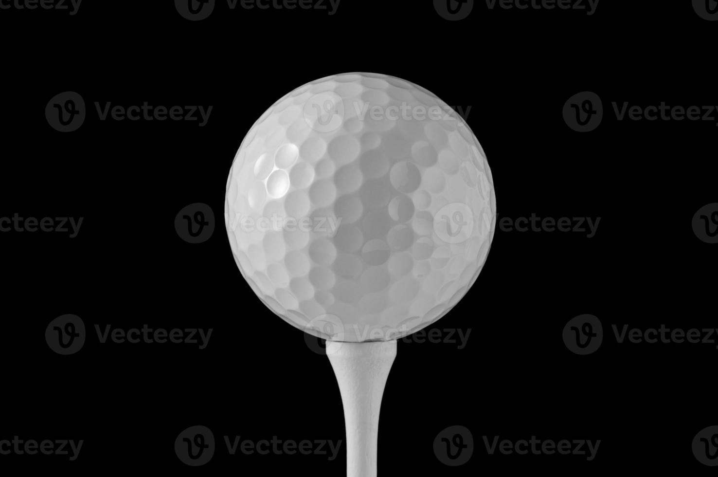 Golfball auf Tee, schwarzer Hintergrund foto