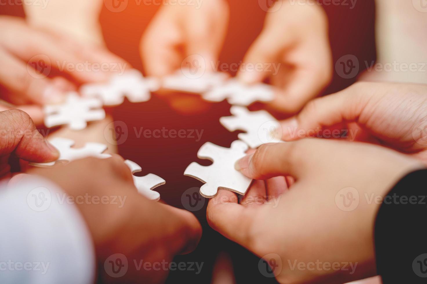 nahaufnahme des geschäftsmannes mit puzzleteilen im büro teamarbeit einheit in der teamarbeit das konzept der kombination von stärke und macht foto