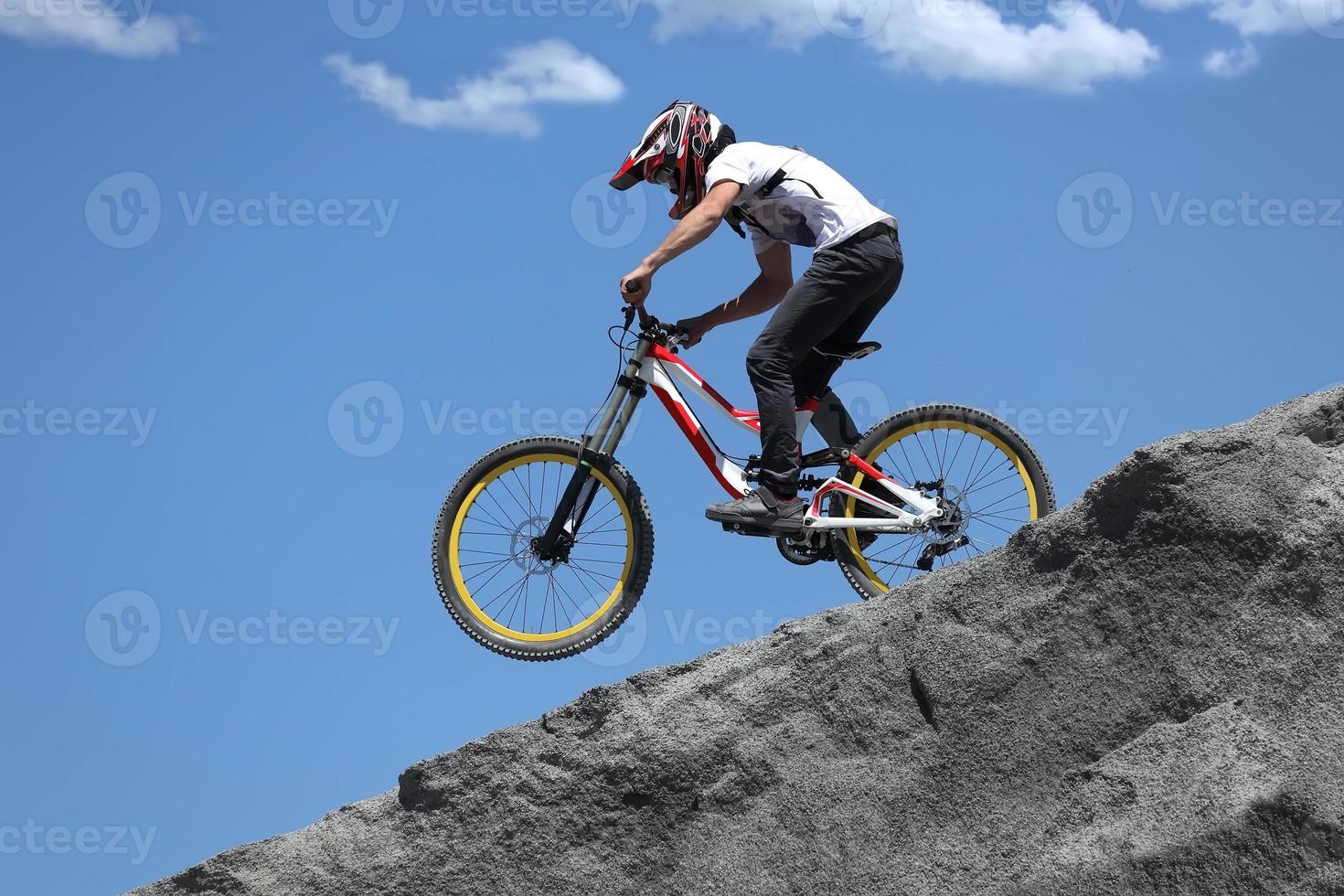 Sportler in Sportbekleidung auf einem Mountainbike fährt auf den Steinen foto