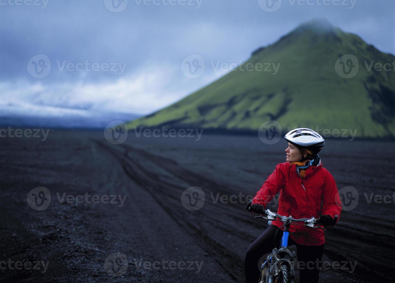 Frau Mountainbiken in der ländlichen Landschaft foto